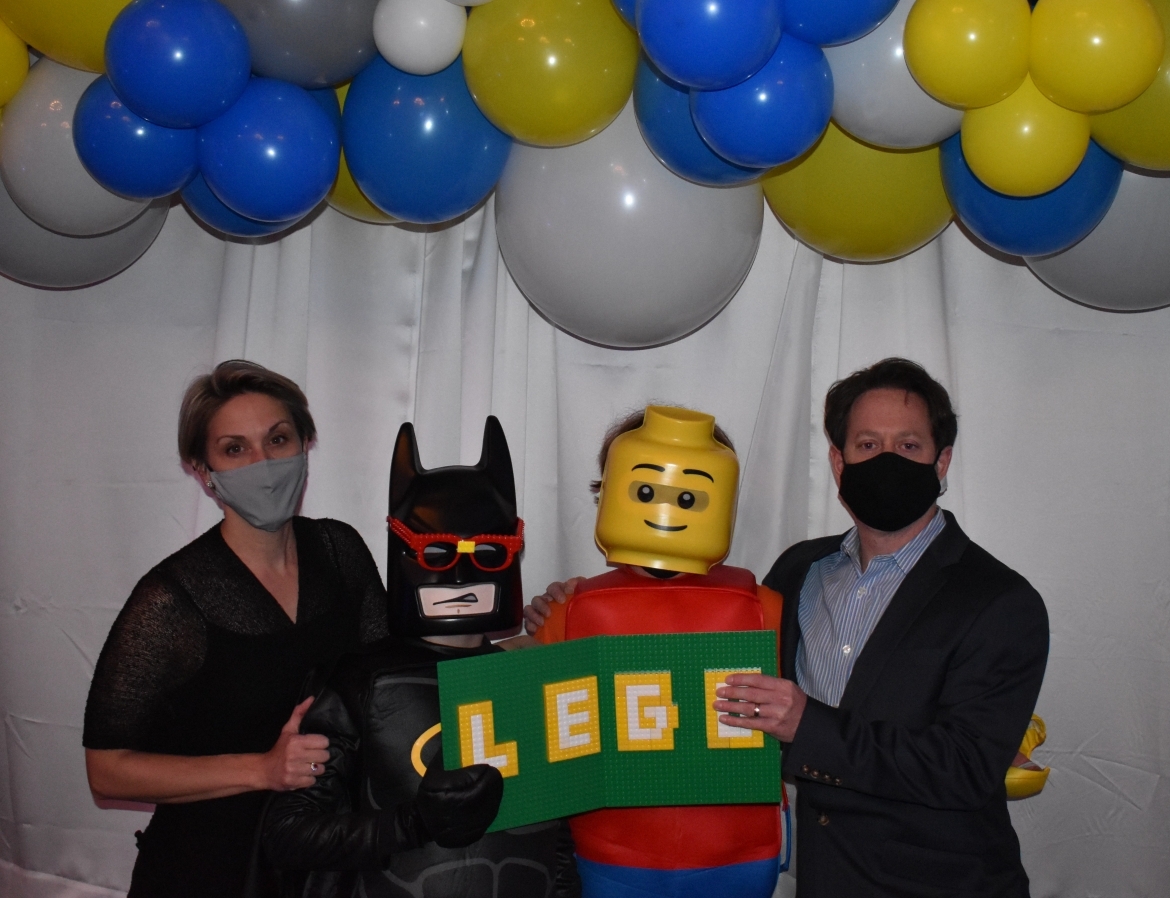 Two people with Batman and LEGO Man and LEGO sign